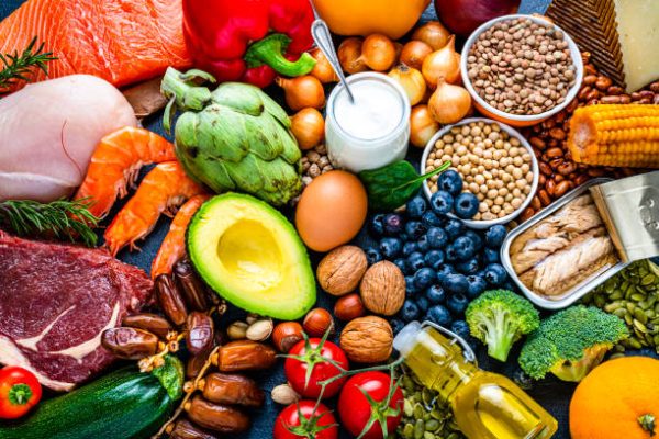 Overhead view of a large group of healthy raw food for flexitarian mediterranean diet. The composition includes salmon, chicken breast, canned tuna, cow steak,  fruits, vegetables, nuts, seeds, dairi products, olive oil, eggs and legumes. High resolution 42Mp studio digital capture taken with SONY A7rII and Zeiss Batis 40mm F2.0 CF lens