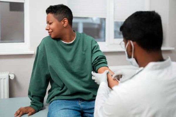 Teenager receiving a vaccination from a healthcare provider ahead of school resumption in Nigeria